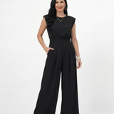 Enterizo negro con hombrera y manga corta estructurada, cintura elástica fruncida y pierna ancha con pinzas, perfecto para eventos y salidas nocturnas