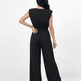 Enterizo negro con hombrera y manga corta estructurada, cintura elástica fruncida y pierna ancha con pinzas, perfecto para eventos y salidas nocturnas
