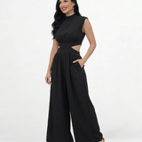 Enterizo negro cut out con cuello alto, hombrera estructurada, aberturas en cintura y pierna ancha con vuelo, elegante para eventos y salidas de noche