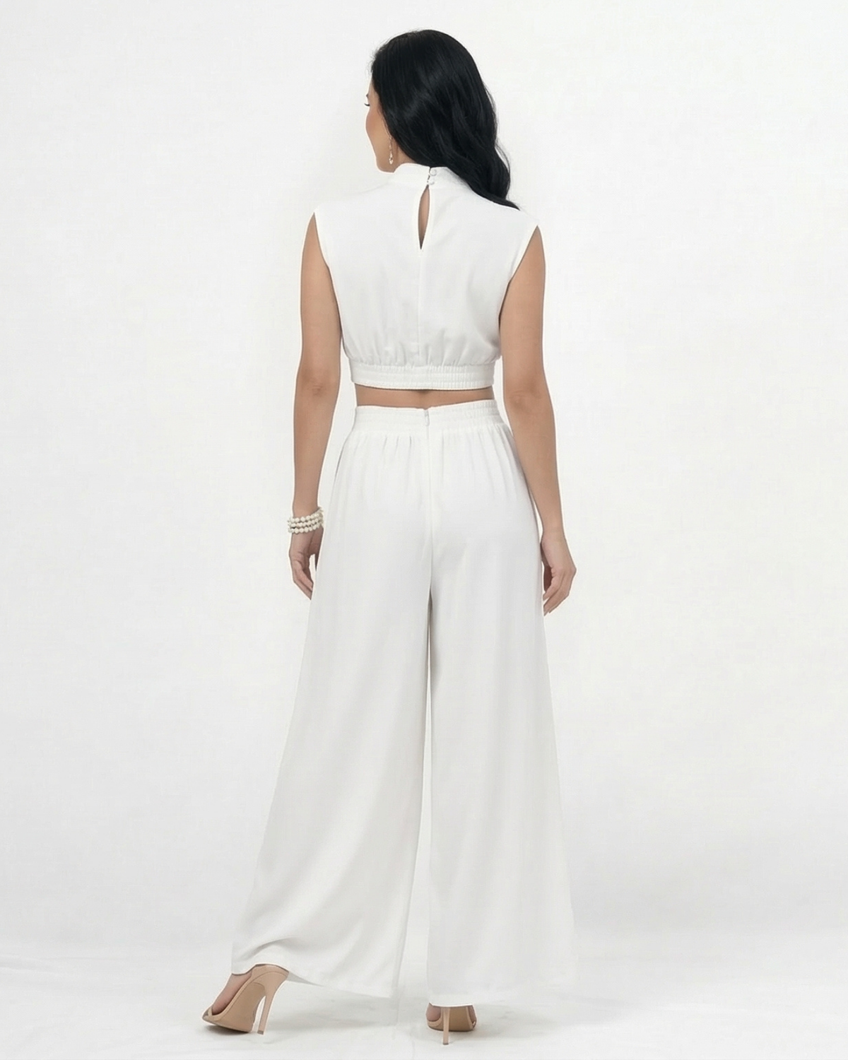 Enterizo blanco cut out con cuello alto y hombrera, aberturas laterales en cintura y falda pantalón ancha, sofisticado para eventos especiales y cócteles