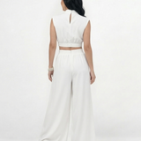 Enterizo blanco cut out con cuello alto y hombrera, aberturas laterales en cintura y falda pantalón ancha, sofisticado para eventos especiales y cócteles