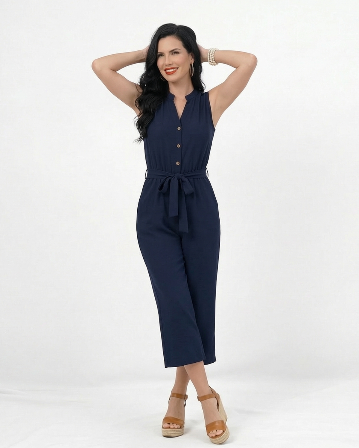 Enterizo azul marino sin mangas con cuello mao abierto, botonadura delantera, lazo en cintura y pierna culotte, elegante para salidas de día y reuniones