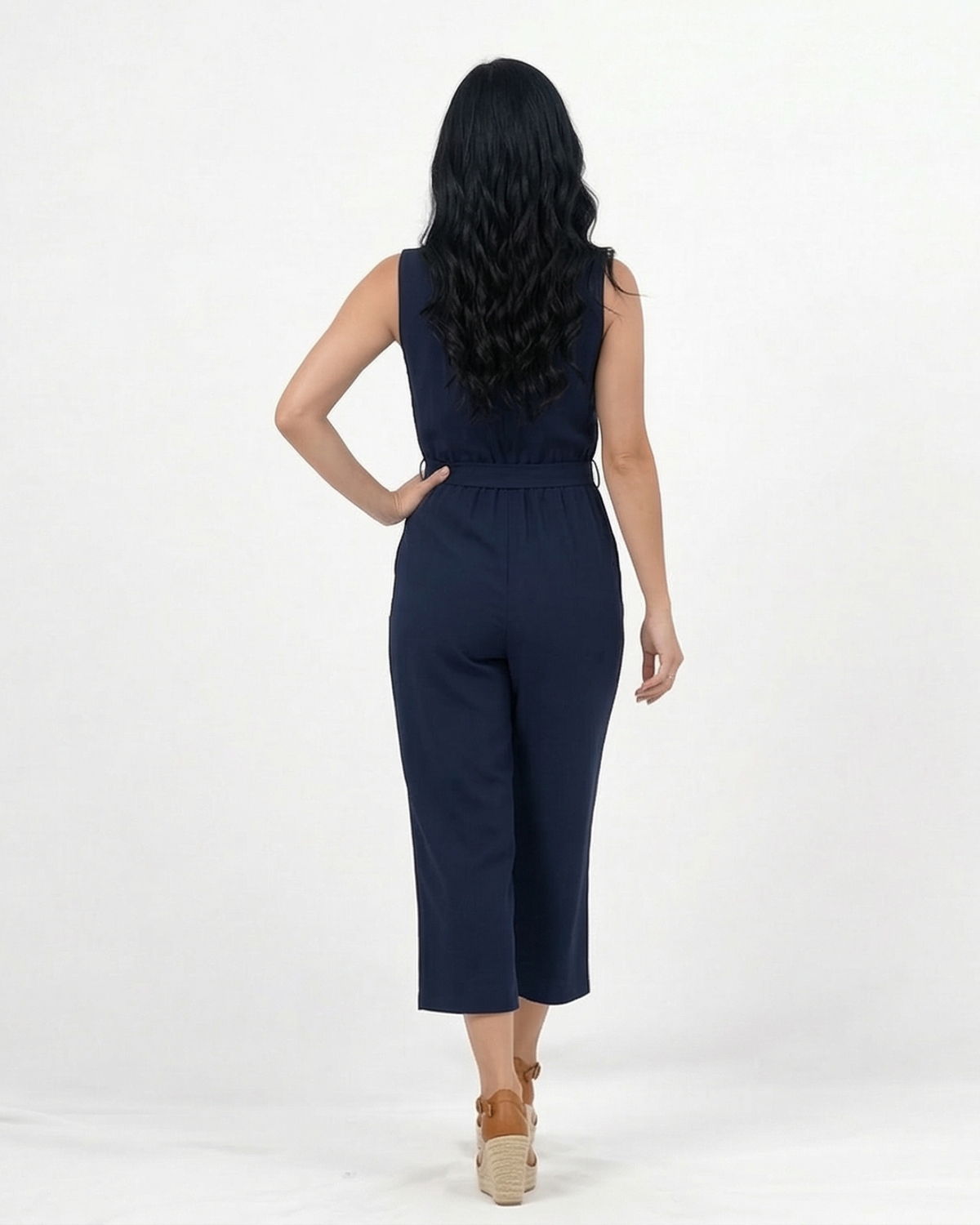 Enterizo azul marino sin mangas con cuello mao abierto, botonadura delantera, lazo en cintura y pierna culotte, elegante para salidas de día y reuniones
