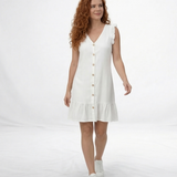 Vestido corto blanco en lino con escote en V, botones decorativos y volante en hombros y ruedo, ideal para vacaciones y planes de verano