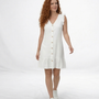 Vestido corto blanco en lino con escote en V, botones decorativos y volante en hombros y ruedo, ideal para vacaciones y planes de verano