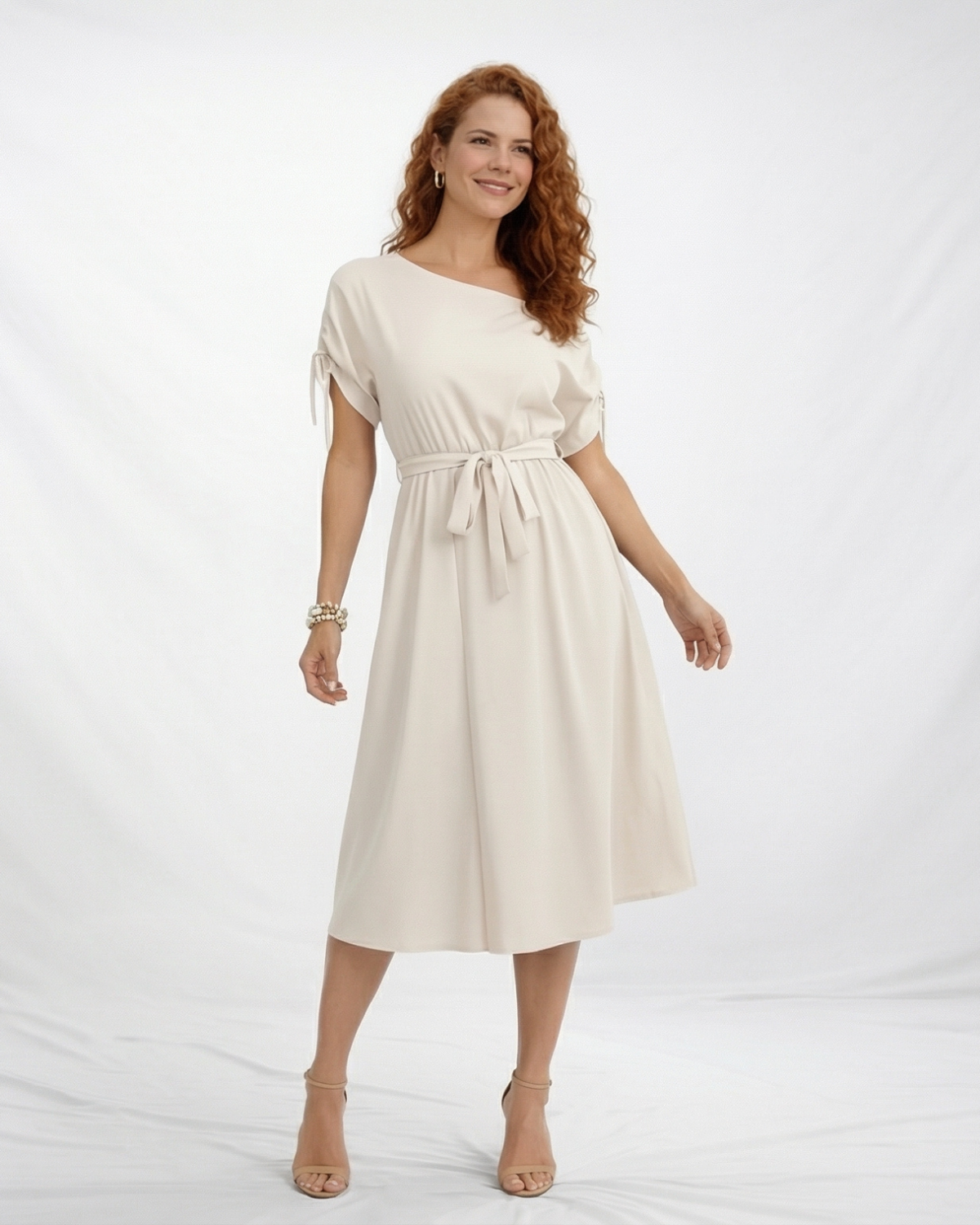 Vestido midi marfil con hombro asimétrico descubierto, manga corta con lazo en puño, cintura con lazo y falda con vuelo, elegante para eventos y cenas especiales