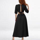 Vestido midi negro con escote en V cruzado, manga 3/4 abullonada y aberturas cut out en cintura, sofisticado para cócteles y salidas de noche