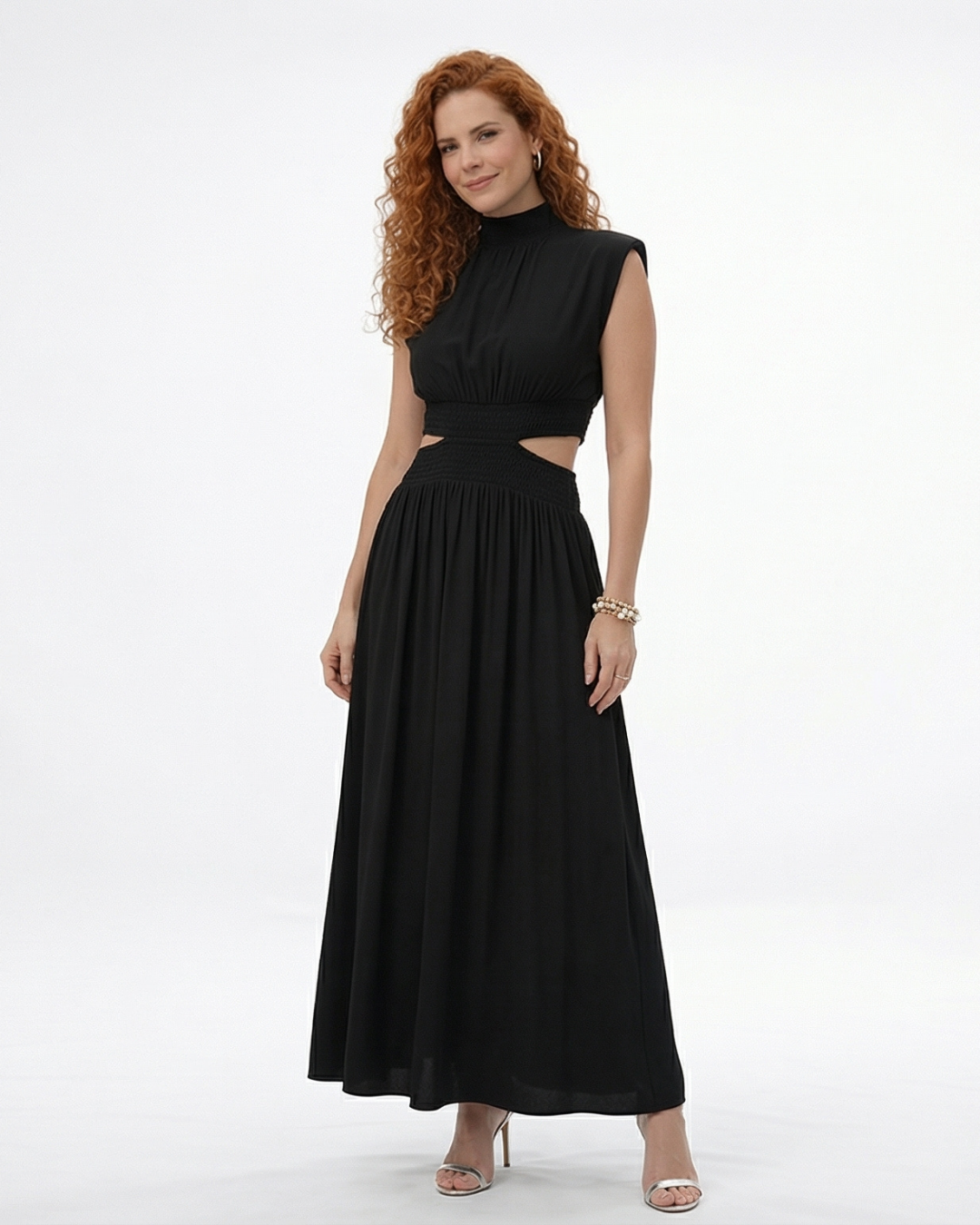 Vestido largo negro cuello alto con abertura cut out en cintura y falda acampanada fruncida, sofisticado y elegante para fiestas, grados y eventos especiales en Colombia