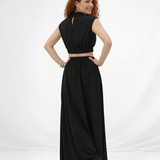 Vestido largo negro cuello alto con abertura cut out en cintura y falda acampanada fruncida, sofisticado y elegante para fiestas, grados y eventos especiales en Colombia