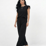 Conjunto negro top sin mangas con volantes en hombros y pantalón ancho pierna recta, sofisticado y versátil para fiestas, grados y salidas elegantes en Colombia