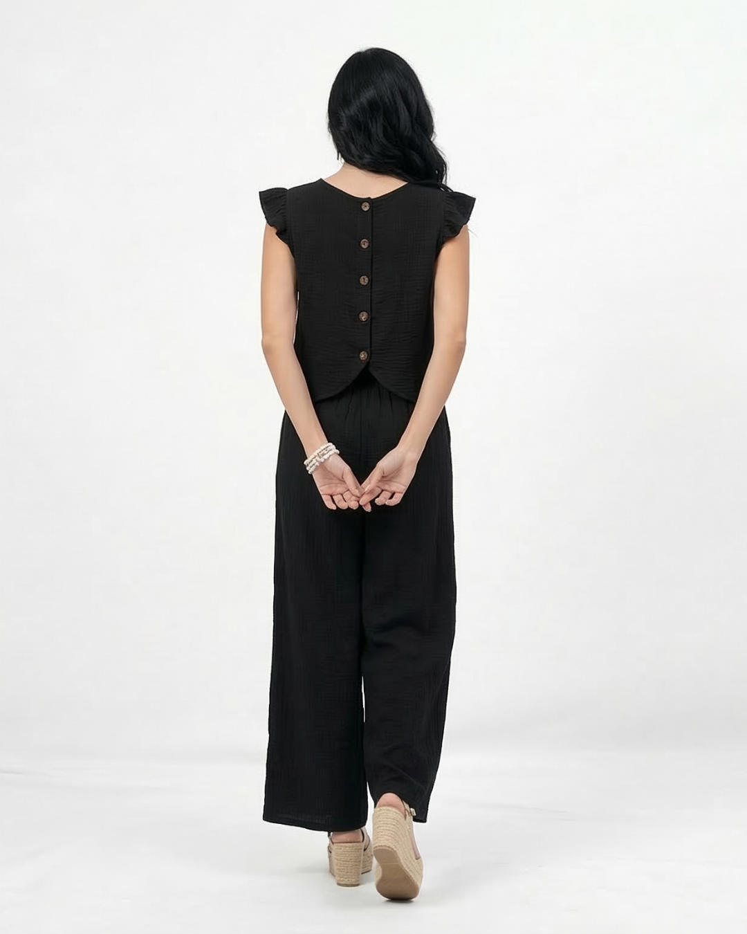 Conjunto negro top sin mangas con volantes en hombros y pantalón ancho pierna recta, sofisticado y versátil para fiestas, grados y salidas elegantes en Colombia