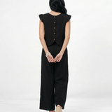 Conjunto negro top sin mangas con volantes en hombros y pantalón ancho pierna recta, sofisticado y versátil para fiestas, grados y salidas elegantes en Colombia