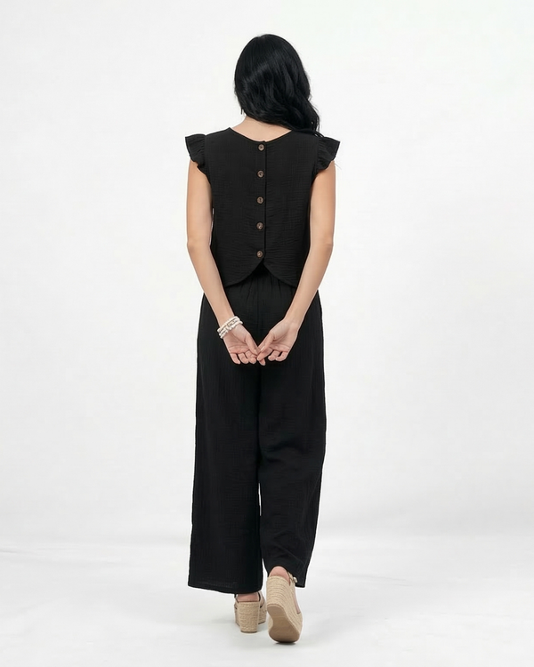 Conjunto negro top sin mangas con volantes en hombros y pantalón ancho pierna recta, sofisticado y versátil para fiestas, grados y salidas elegantes en Colombia