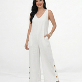 Enterizo blanco en lino sin mangas con escote en V, bolsillos frontales y pierna ancha con botones decorativos, fresco y elegante para vacaciones y salidas de día