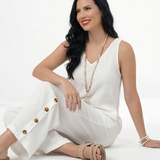 Enterizo blanco en lino sin mangas con escote en V, bolsillos frontales y pierna ancha con botones decorativos, fresco y elegante para vacaciones y salidas de día