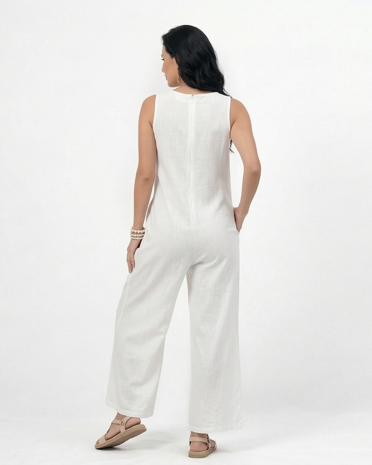 Enterizo blanco en lino sin mangas con escote en V, bolsillos frontales y pierna ancha con botones decorativos, fresco y elegante para vacaciones y salidas de día