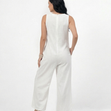 Enterizo blanco en lino sin mangas con escote en V, bolsillos frontales y pierna ancha con botones decorativos, fresco y elegante para vacaciones y salidas de día