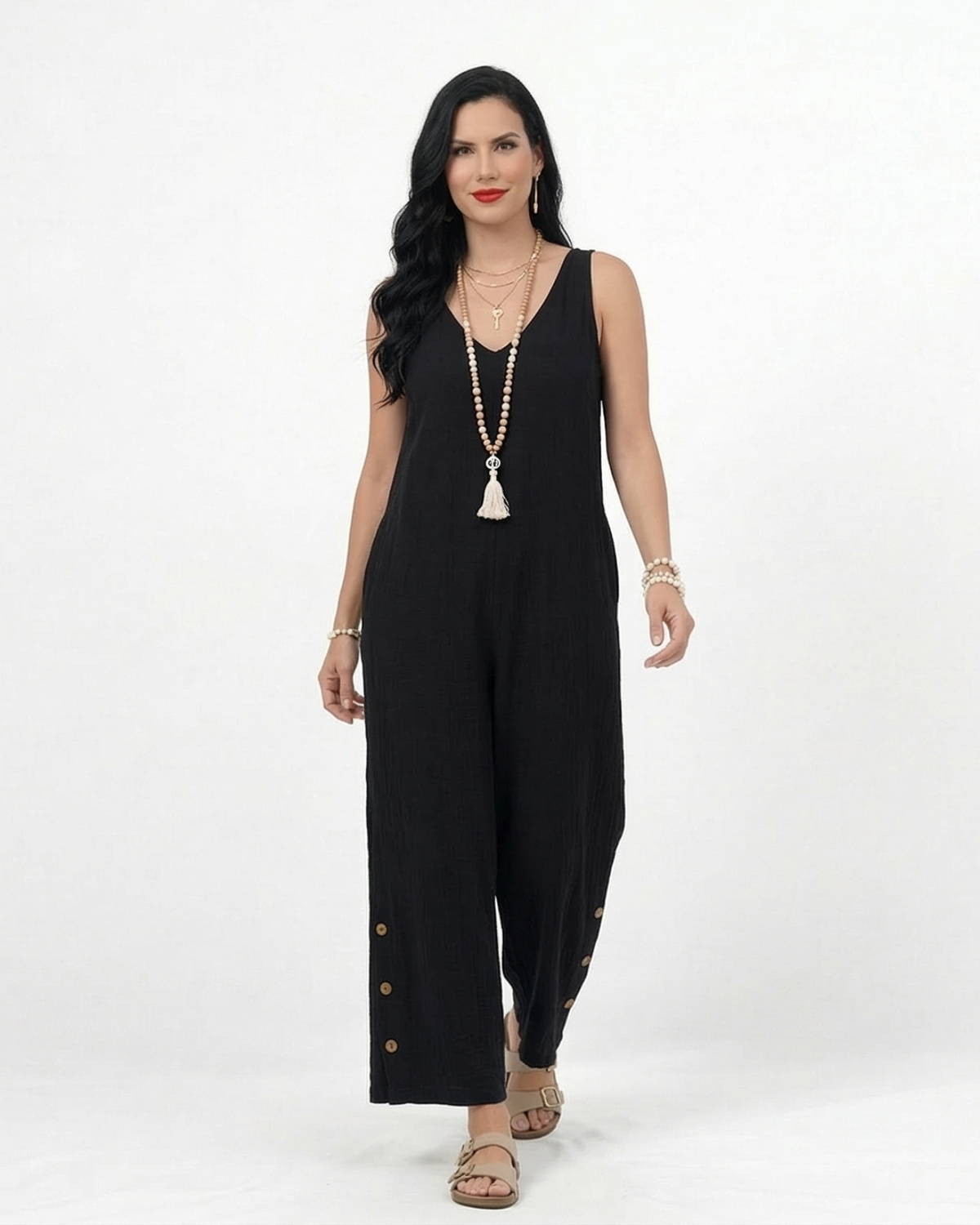 Enterizo negro en lino sin mangas con escote en V, pierna ancha y botones decorativos laterales, versátil para salidas de día y eventos casuales