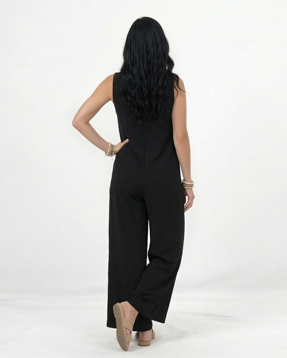 Enterizo negro en lino sin mangas con escote en V, pierna ancha y botones decorativos laterales, versátil para salidas de día y eventos casuales