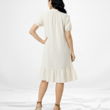 Vestido corto crema tipo camisero con cuello de camisa, manga corta globo, botones al frente y volante en el ruedo, fresco y casual para salidas de día y paseos