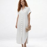 Vestido largo blanco tipo camisero con cuello de camisa, botones al frente, manga corta y abertura lateral, ideal para salidas casuales elegantes y días de calor