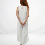 Vestido largo blanco sin mangas cuello redondo con falda cruzada y abertura frontal, elegante para matrimonios de día y salidas especiales en Colombia