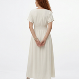 Vestido largo crema con escote en V profundo, botones al frente, manga corta y abertura en la falda, ideal para matrimonios de día, grados y eventos especiales