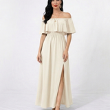 Vestido largo crema con hombros descubiertos, volante en el busto, cintura elástica y abertura frontal en la falda, ideal para matrimonios de día, grados y eventos especiales