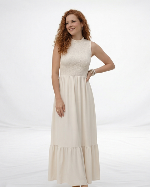 Vestido largo crema sin mangas con cuerpo fruncido, cuello alto y falda larga con volante escalonado, ideal para matrimonios de día, grados y eventos especiales