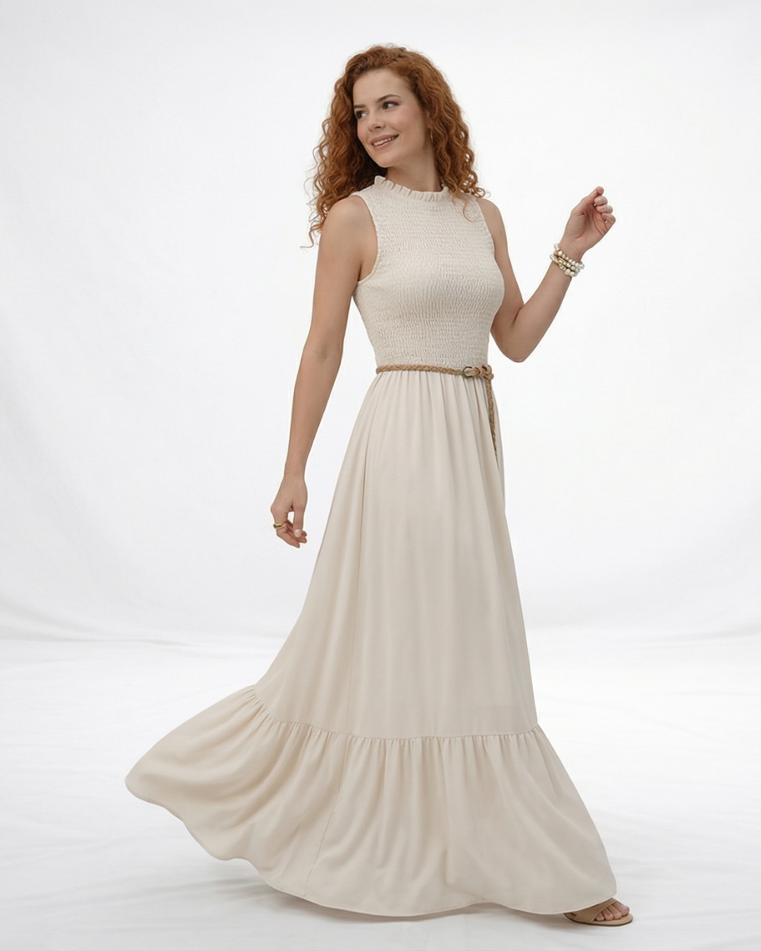 Vestido largo crema sin mangas con cuerpo fruncido, cuello alto y falda larga con volante escalonado, ideal para matrimonios de día, grados y eventos especiales