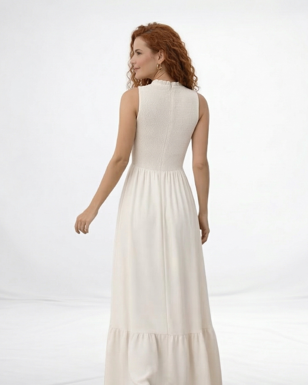 Vestido largo crema sin mangas con cuerpo fruncido, cuello alto y falda larga con volante escalonado, ideal para matrimonios de día, grados y eventos especiales